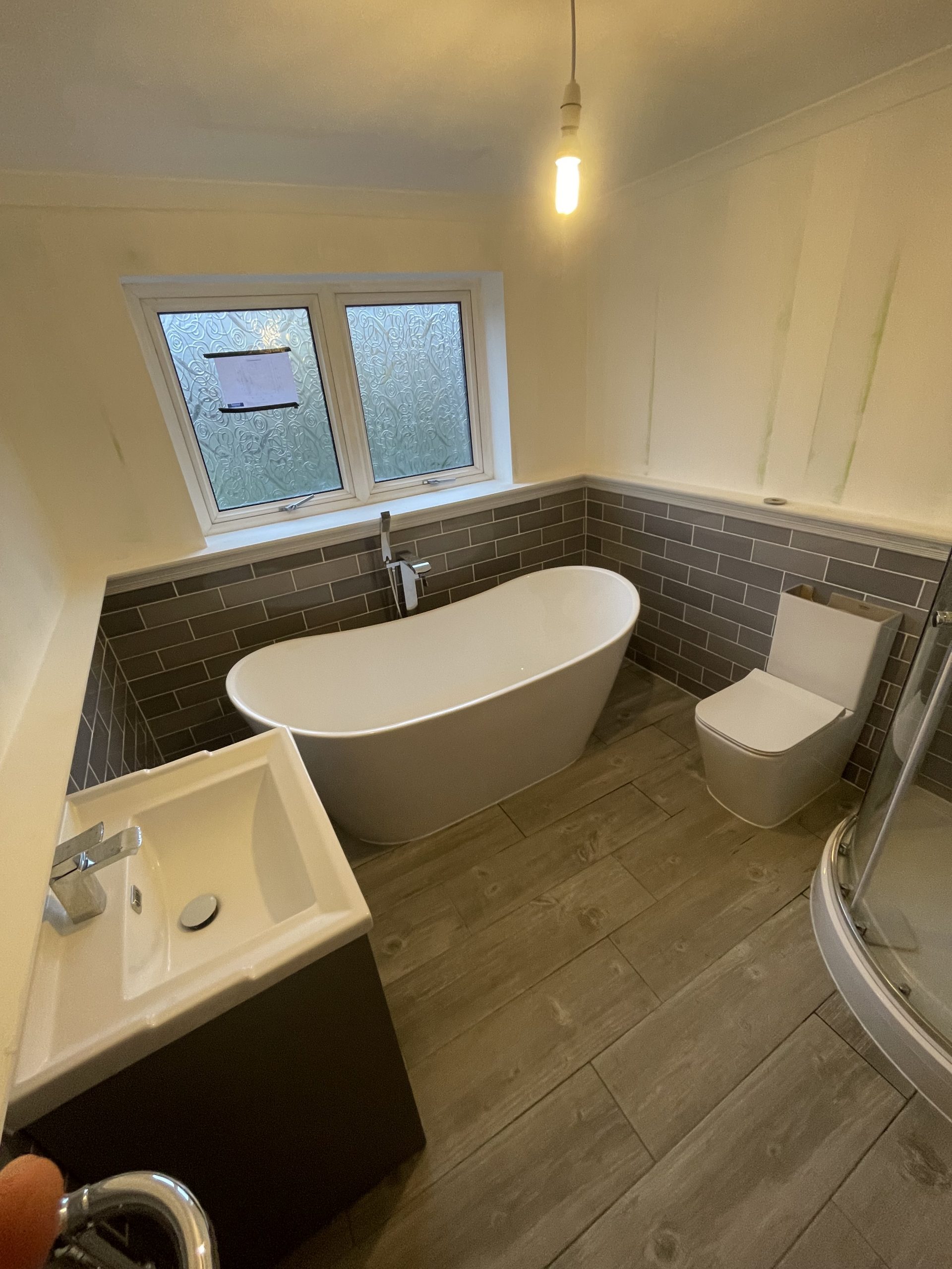 Complete bathroom refurbishment Reading with freestanding bath and dark tiles