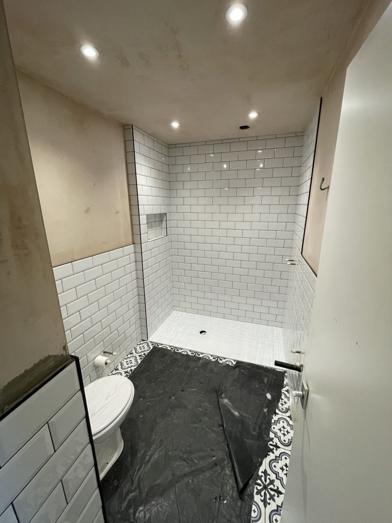 Bespoke shower niche design integrated into white subway tiling for a premium finish.